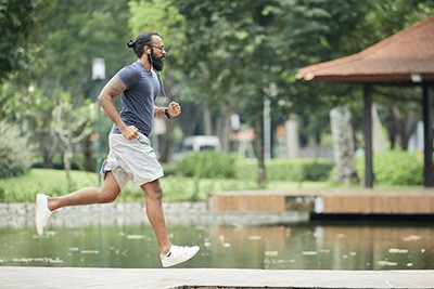 boy with long hair running in shorts